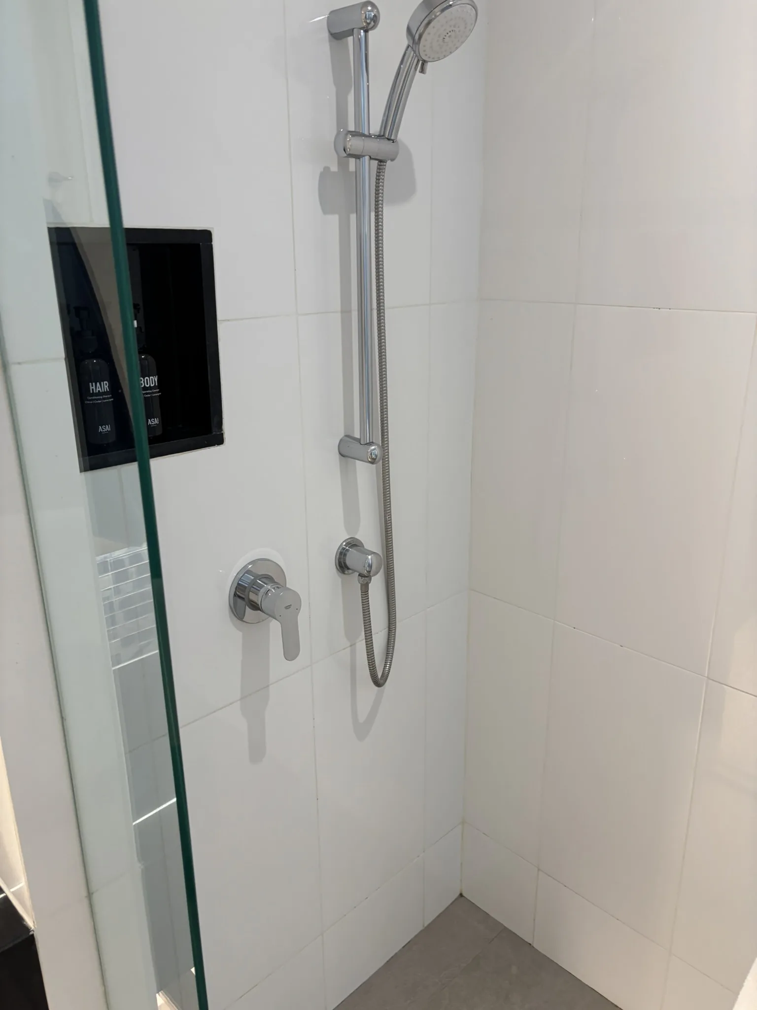 Walk-in glass shower with chrome fittings and ASAI branded shampoo and body wash at ASAI Bangkok Chinatown