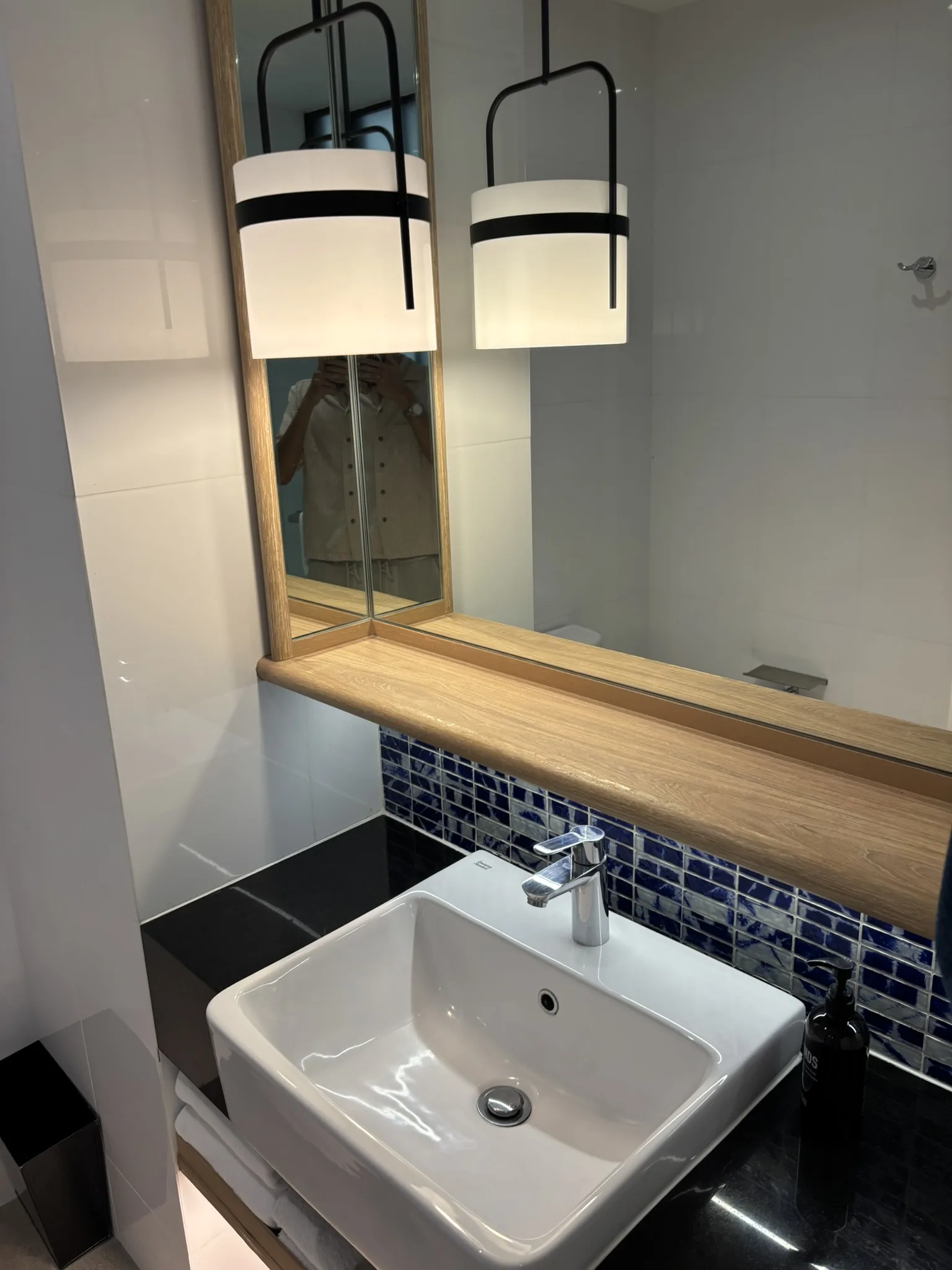 Bathroom vanity with vessel sink, blue mosaic tile backsplash, and framed mirror at ASAI Bangkok Chinatown