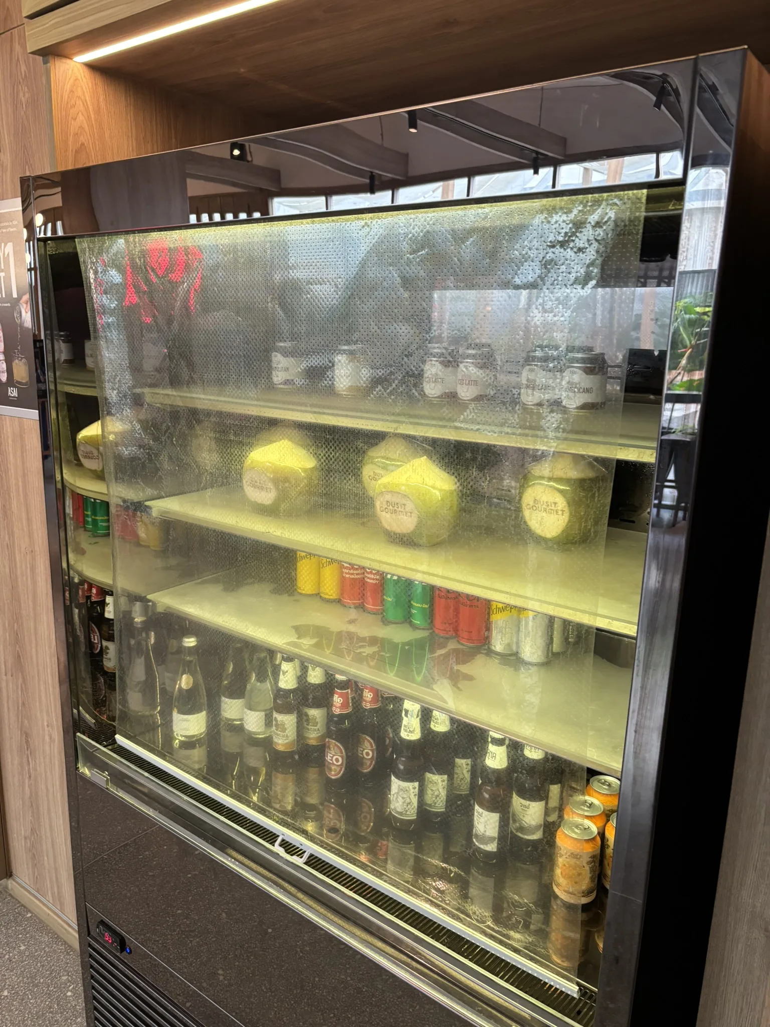 Refrigerated display case stocked with drinks, snacks, and bottled beverages at ASAI Bangkok Chinatown