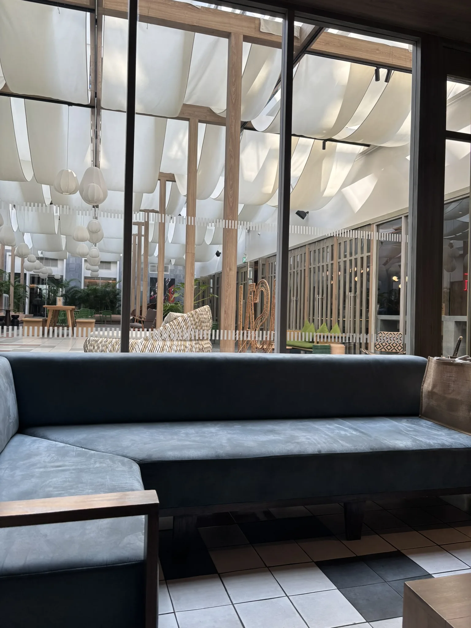 Comfortable lobby seating bench with floor-to-ceiling windows overlooking the terrace at ASAI Bangkok Chinatown