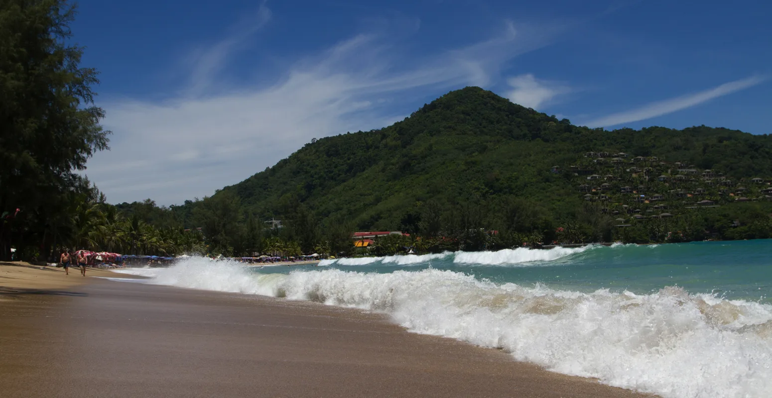 Kamala Beach Phuket Thailand quiet cove with palm trees and calm turquoise water