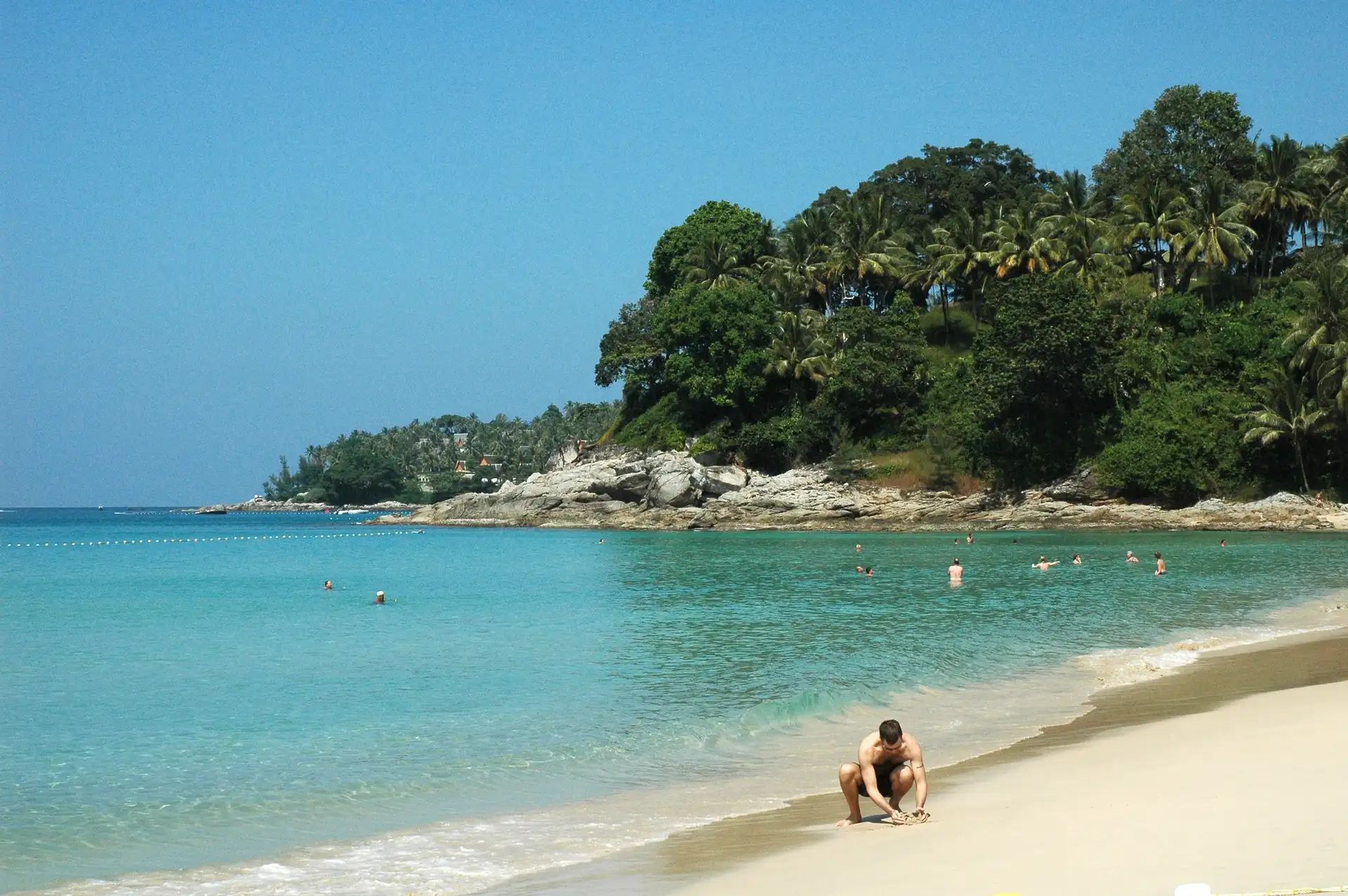 Surin Beach Phuket Thailand crystal clear turquoise water and lush green hillside