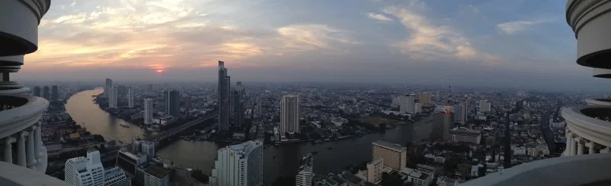 Panoramic sunset view from Lebua at State Tower Bangkok rooftop over the Chao Phraya River