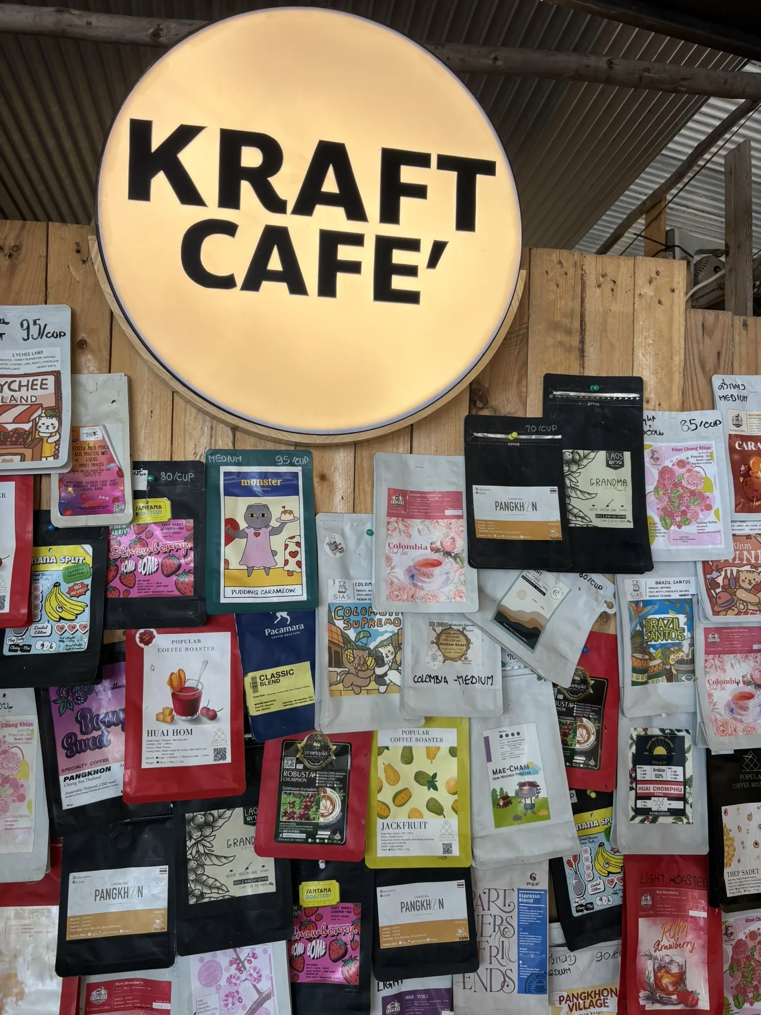 Wall of single-origin coffee bags under the Kraft Cafe sign in Hua Hin