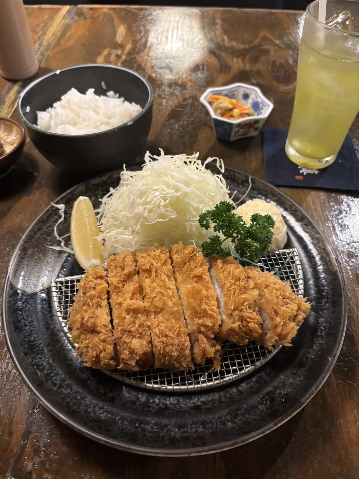 Sliced tonkatsu on a wire rack with shredded cabbage and rice at Katsushin, Surawong
