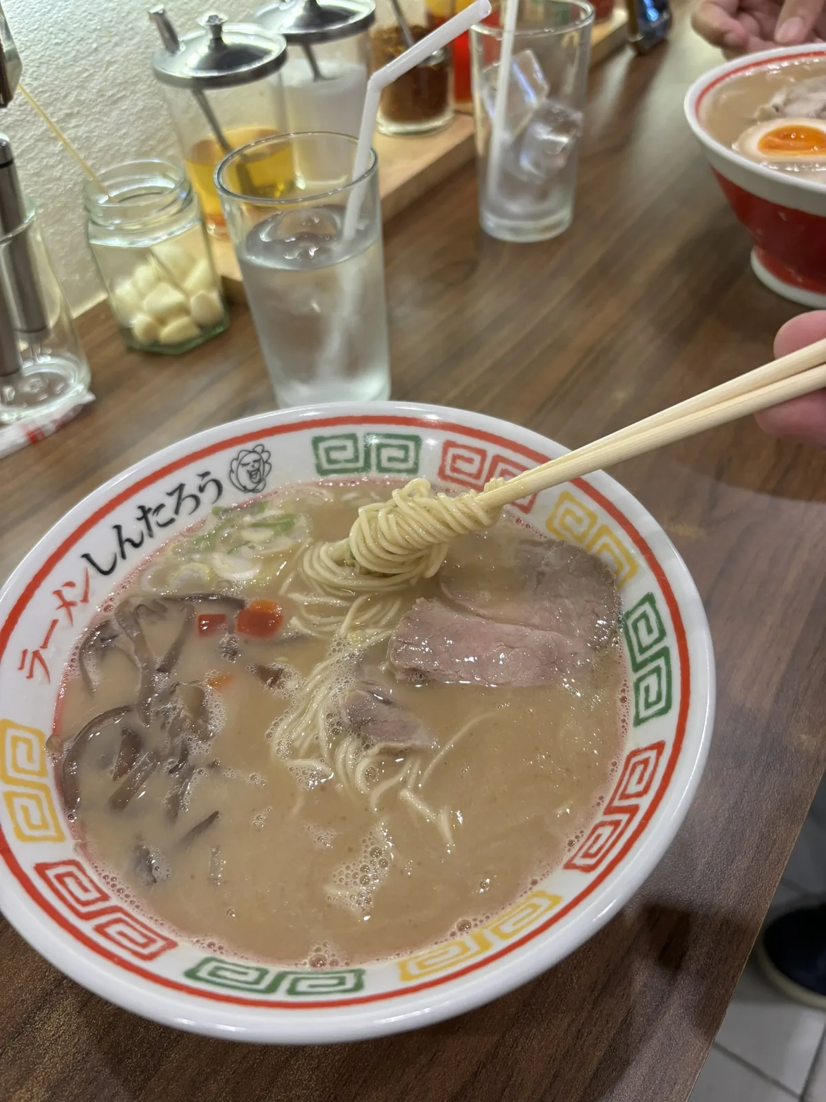 Bowl of tonkotsu ramen with chashu in a branded bowl at Ramen Shintaro, Sukhumvit